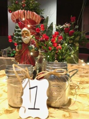 Festive holiday floral display featuring Santa, red berries, and twinkling lights.