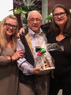 Three women and an elderly man celebrating at Charlotte Garden Club event.