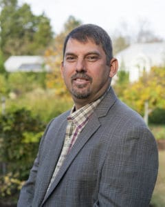 Charlotte Garden Club member in garden setting with lush greenery.